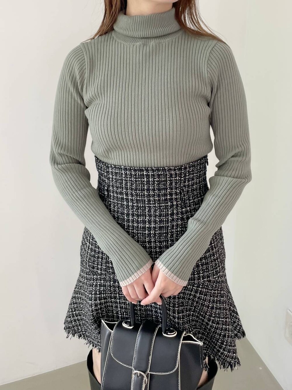 ブラック系のハンドバッグ、ブラック系のブーツ、ブラック系のノーカラージャケットを着用したレディースの秋コーディネートの5枚目の写真