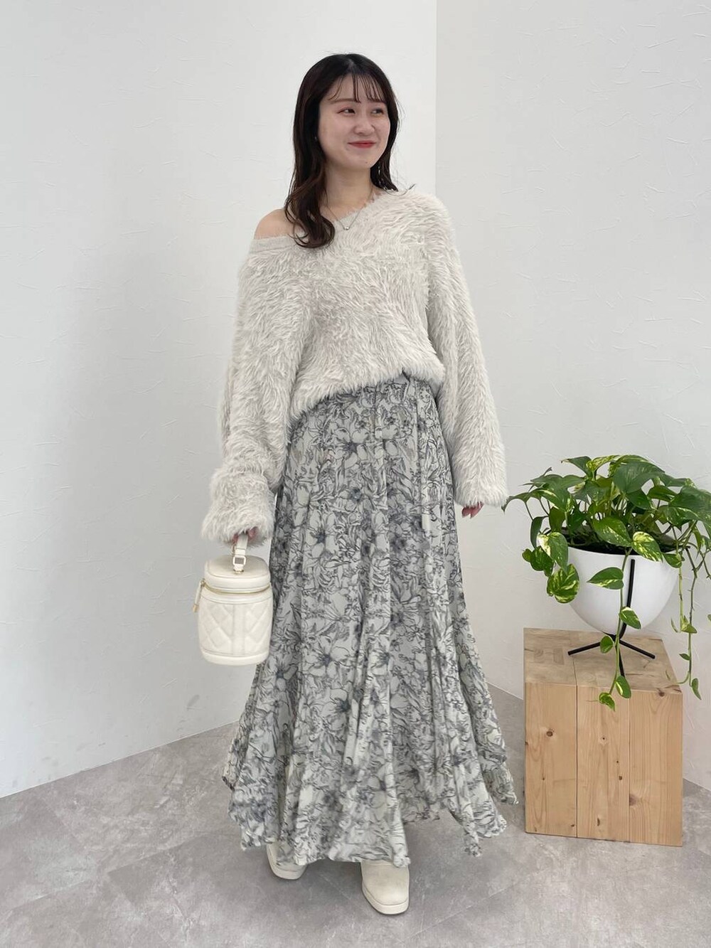 ホワイト系のブーツ、ベージュ系のスカート、ホワイト系のショルダーバッグを着用したレディースの冬コーディネートの4枚目の写真