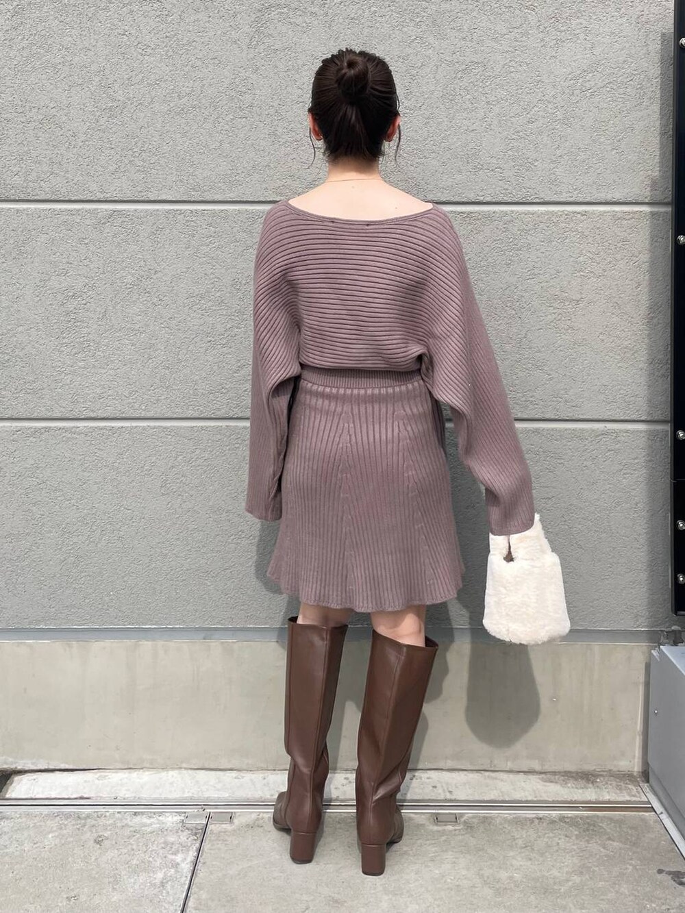 ブラウン系のブーツ、ホワイト系のハンドバッグ、ブラウン系のワンピースを着用したレディースの秋コーディネートの2枚目の写真