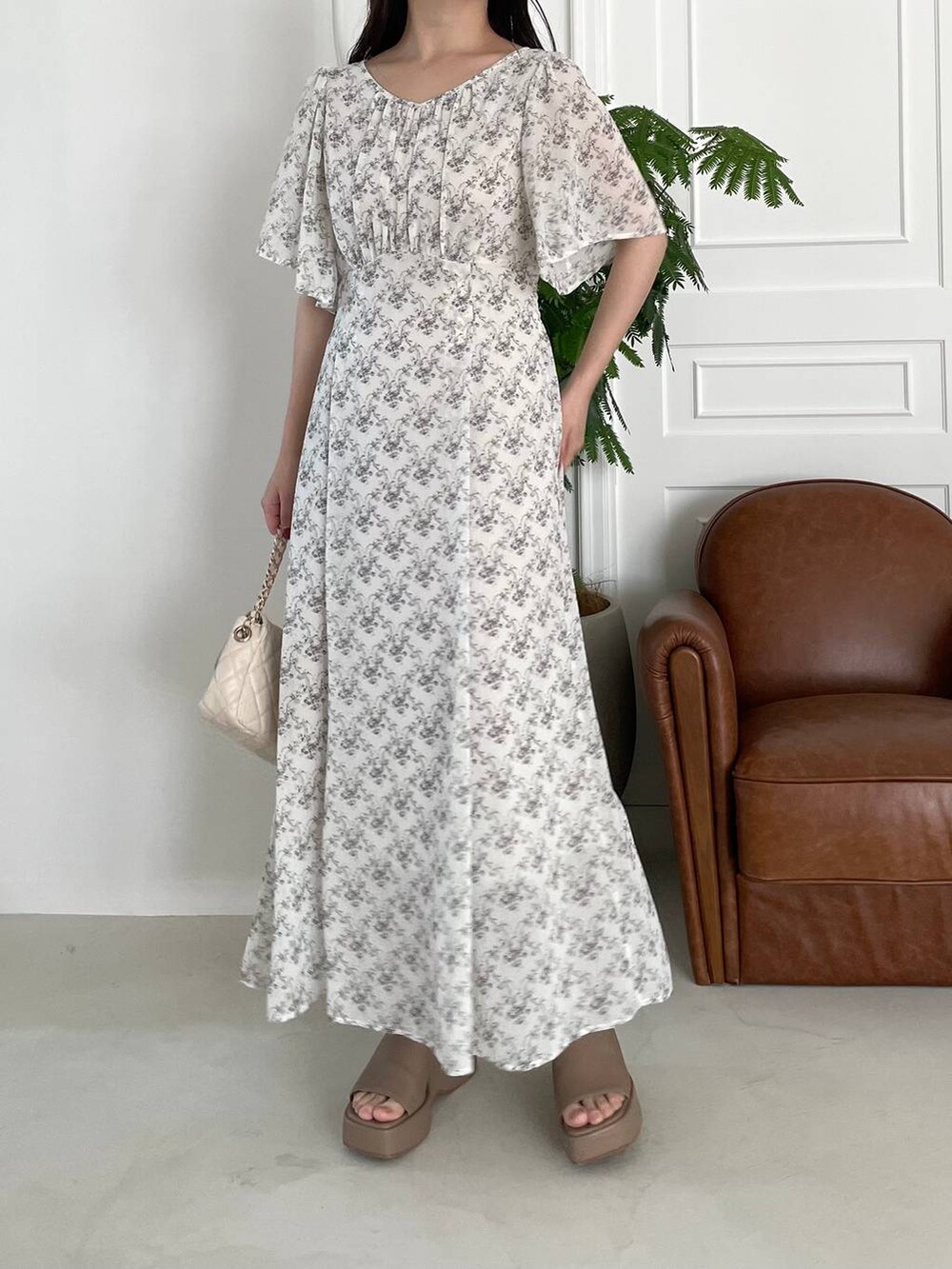 ベージュ系のサンダル、ホワイト系のショルダーバッグ、ホワイト系のワンピースを着用したレディースの夏コーディネートの4枚目の写真