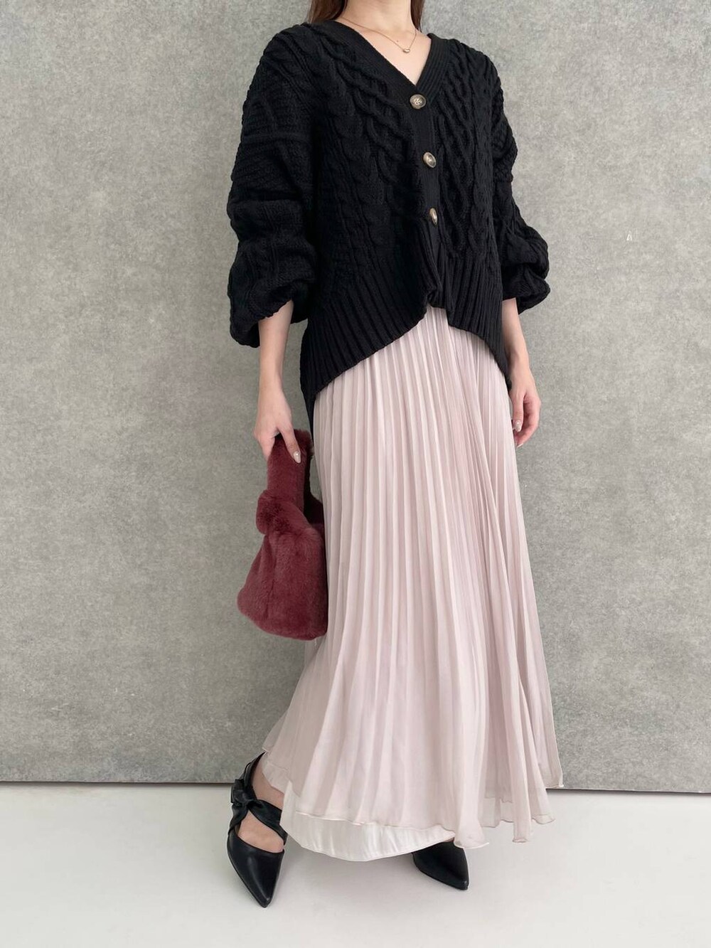 ブラック系のパンプス、ブラック系のカーディガン/ボレロ、ピンク系のハンドバッグを着用したレディースの秋コーディネートの4枚目の写真