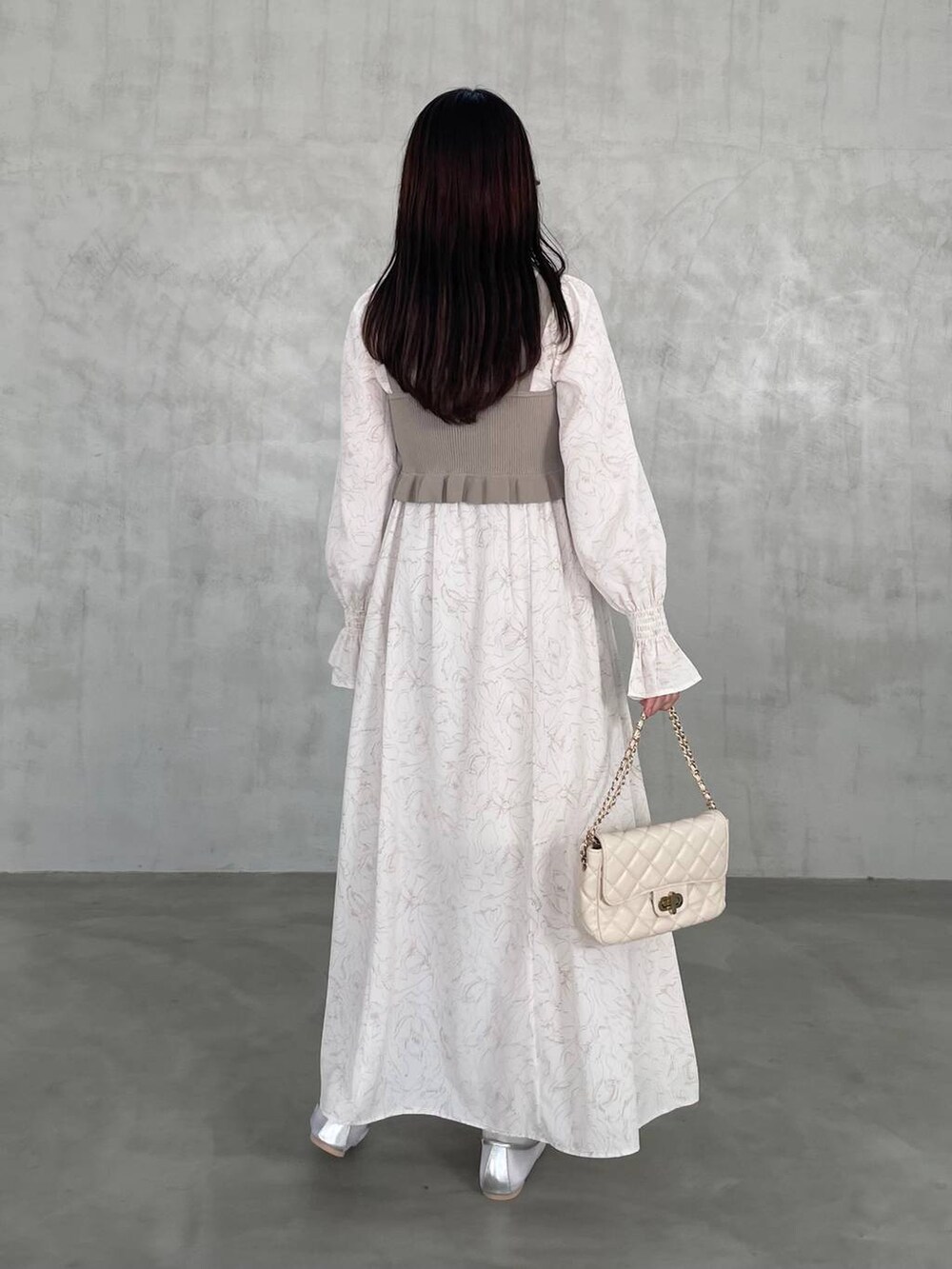 ホワイト系のショルダーバッグ、ベージュ系のワンピースを着用したレディースの冬コーディネートの2枚目の写真