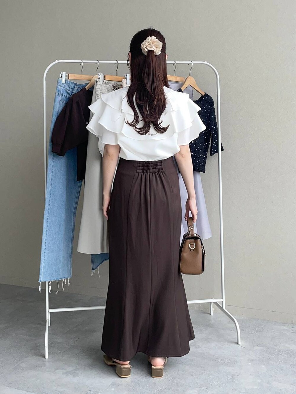 ブラウン系のスカート、ブラウン系のサンダル、ブラウン系のショルダーバッグを着用したレディースの夏コーディネートの2枚目の写真
