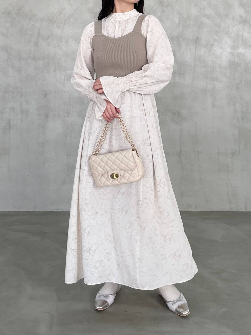 ホワイト系のショルダーバッグ、ベージュ系のワンピースを着用したレディースの冬コーディネートの3枚目の写真