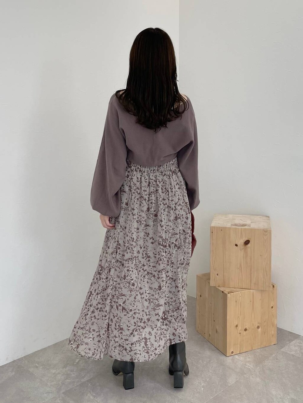 グレー系のブーツ、ピンク系のハンドバッグ、ブラウン系のワンピースを着用したレディースの秋コーディネートの2枚目の写真