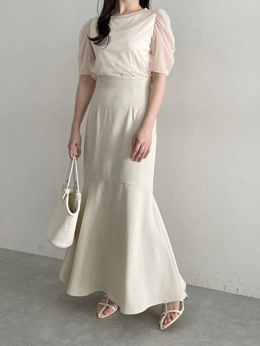 ホワイト系のハンドバッグ、ホワイト系のスカート、ホワイト系のサンダルを着用したレディースの春コーディネートの7枚目の写真