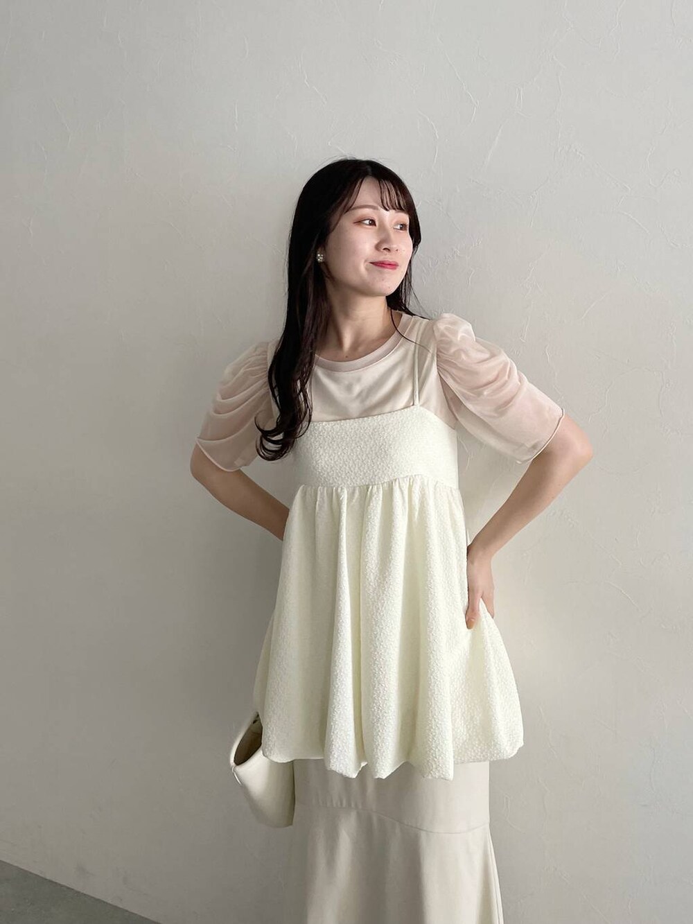 ホワイト系のハンドバッグ、ホワイト系のスカート、ホワイト系のサンダルを着用したレディースの春コーディネートの5枚目の写真