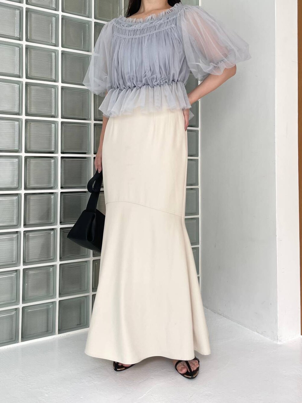 ブラック系のショルダーバッグ、ブラック系のサンダル、ブルー系のシャツ/ブラウスを着用したレディースの夏コーディネートの4枚目の写真