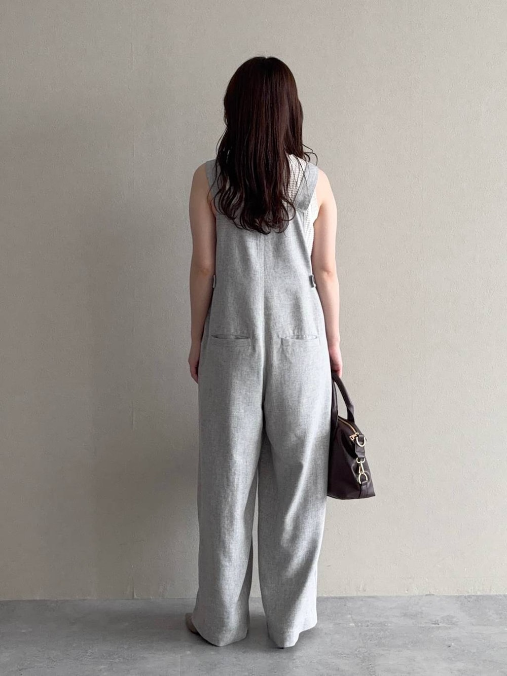 グリーン系のパーカー、ブラウン系のボストンバッグ、ブラウン系のサンダルを着用したレディースの春コーディネートの5枚目の写真