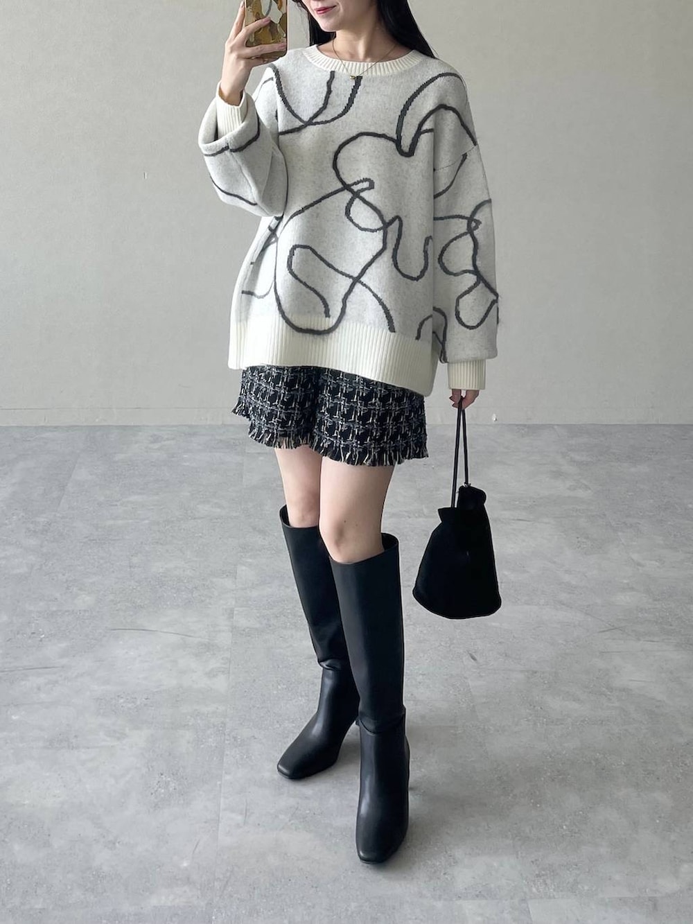 ホワイト系のニット/セーター、ブラック系のその他パンツ、ブラック系のハンドバッグを着用したレディースの秋コーディネートの4枚目の写真