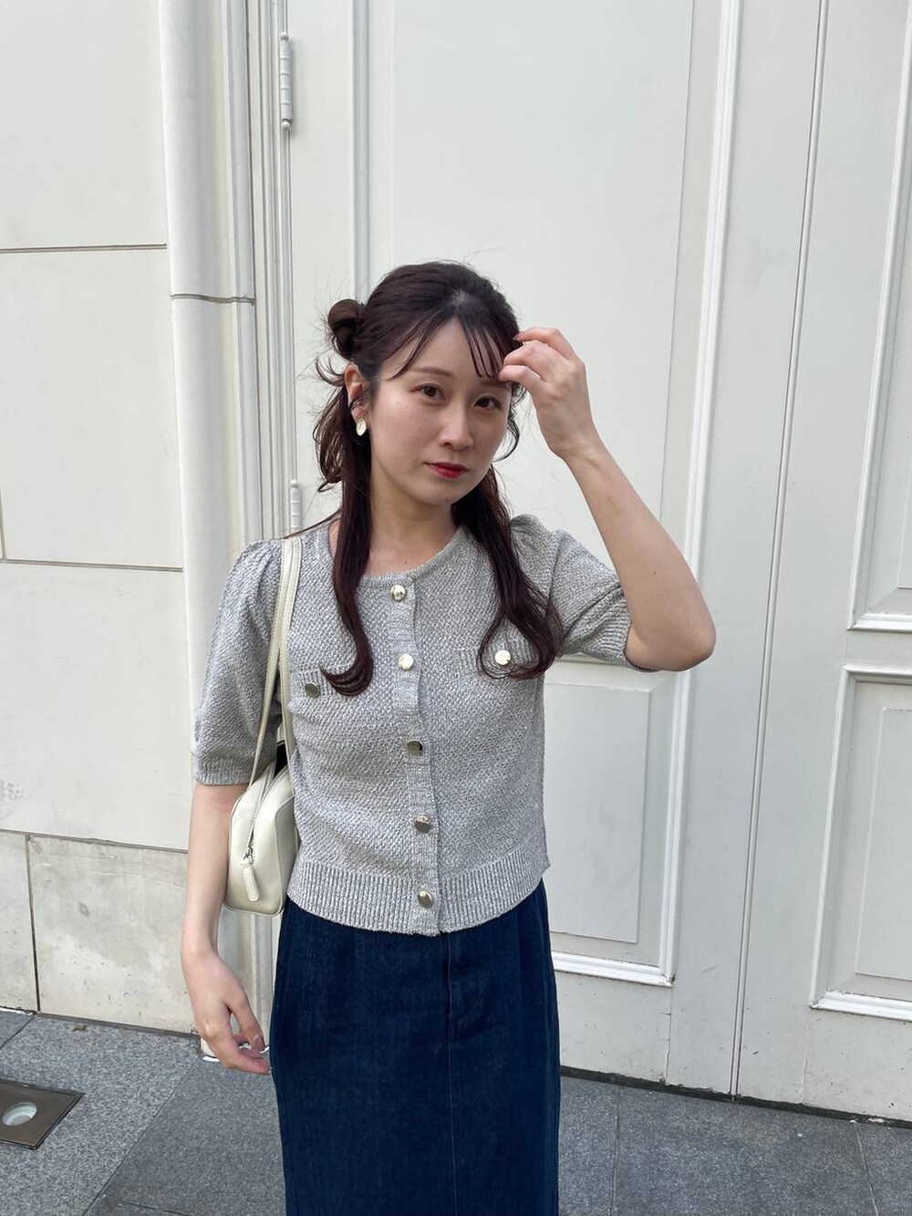 ベージュ系のパンプス、ブルー系のスカート、グレー系のカーディガン/ボレロを着用したレディースの春コーディネートの4枚目の写真