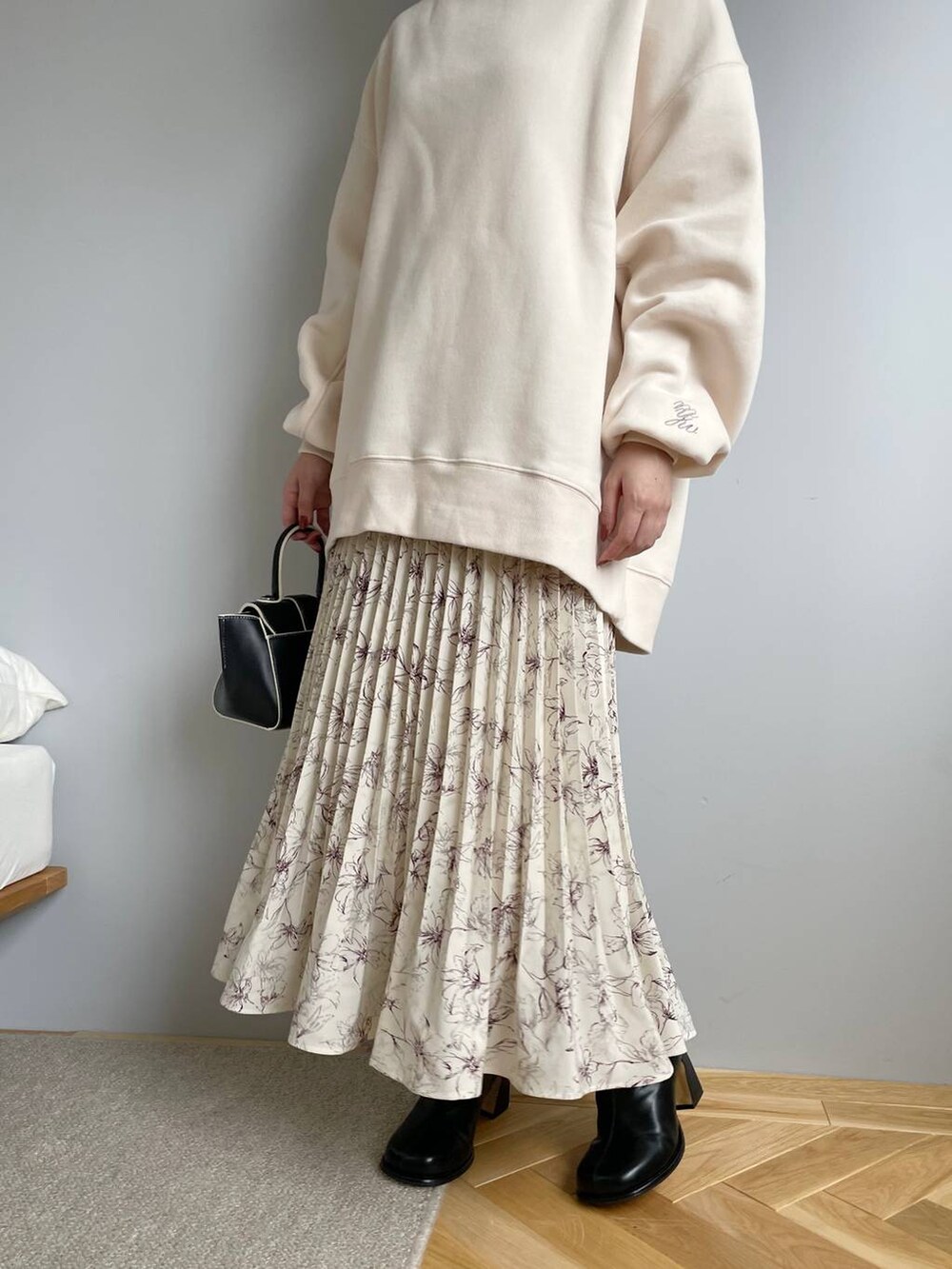 ブラック系のブーツ、ベージュ系のスカート、ホワイト系のスウェットを着用したレディースの秋コーディネートの4枚目の写真