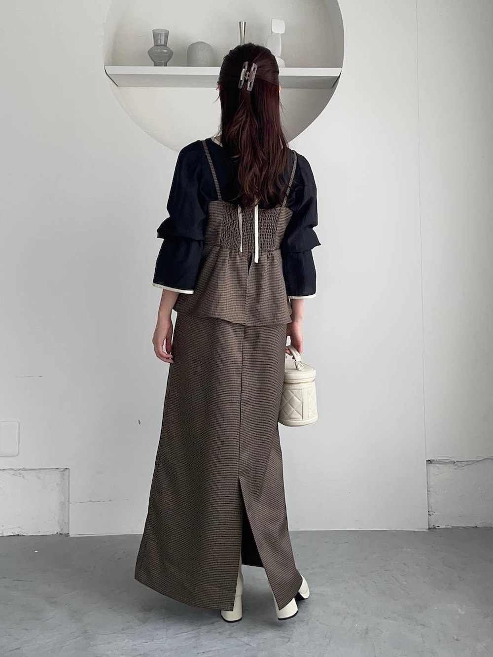 ホワイト系のブーツ、ホワイト系のショルダーバッグ、ブラウン系のワンピースを着用したレディースの冬コーディネートの2枚目の写真