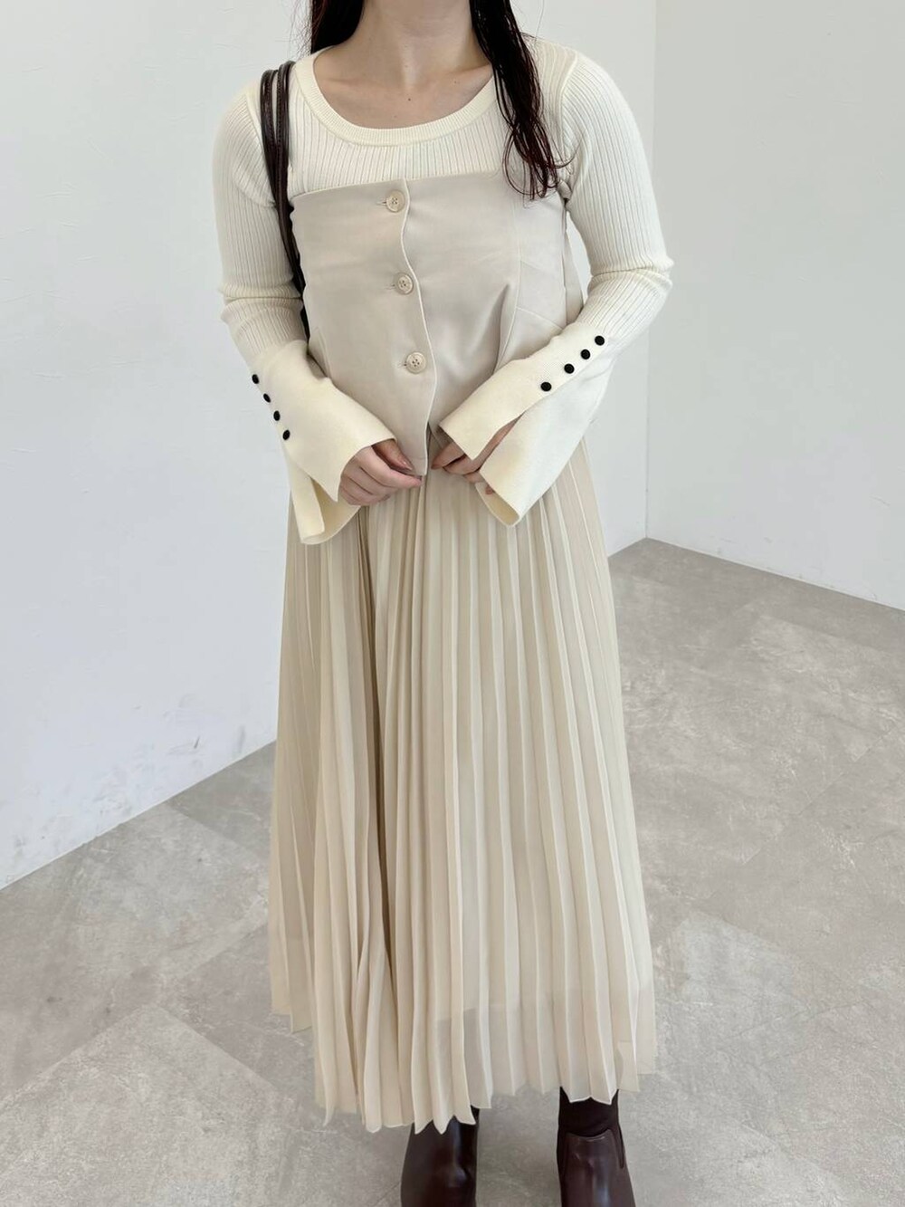 ブラウン系のブーツ、ホワイト系のニット/セーター、ブラウン系のハンドバッグを着用したレディースの冬コーディネートの3枚目の写真