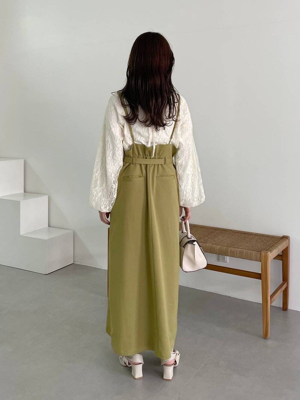 ホワイト系のハンドバッグ、イエロー系のスカート、ホワイト系のパンプスを着用したレディースの秋コーディネートの2枚目の写真