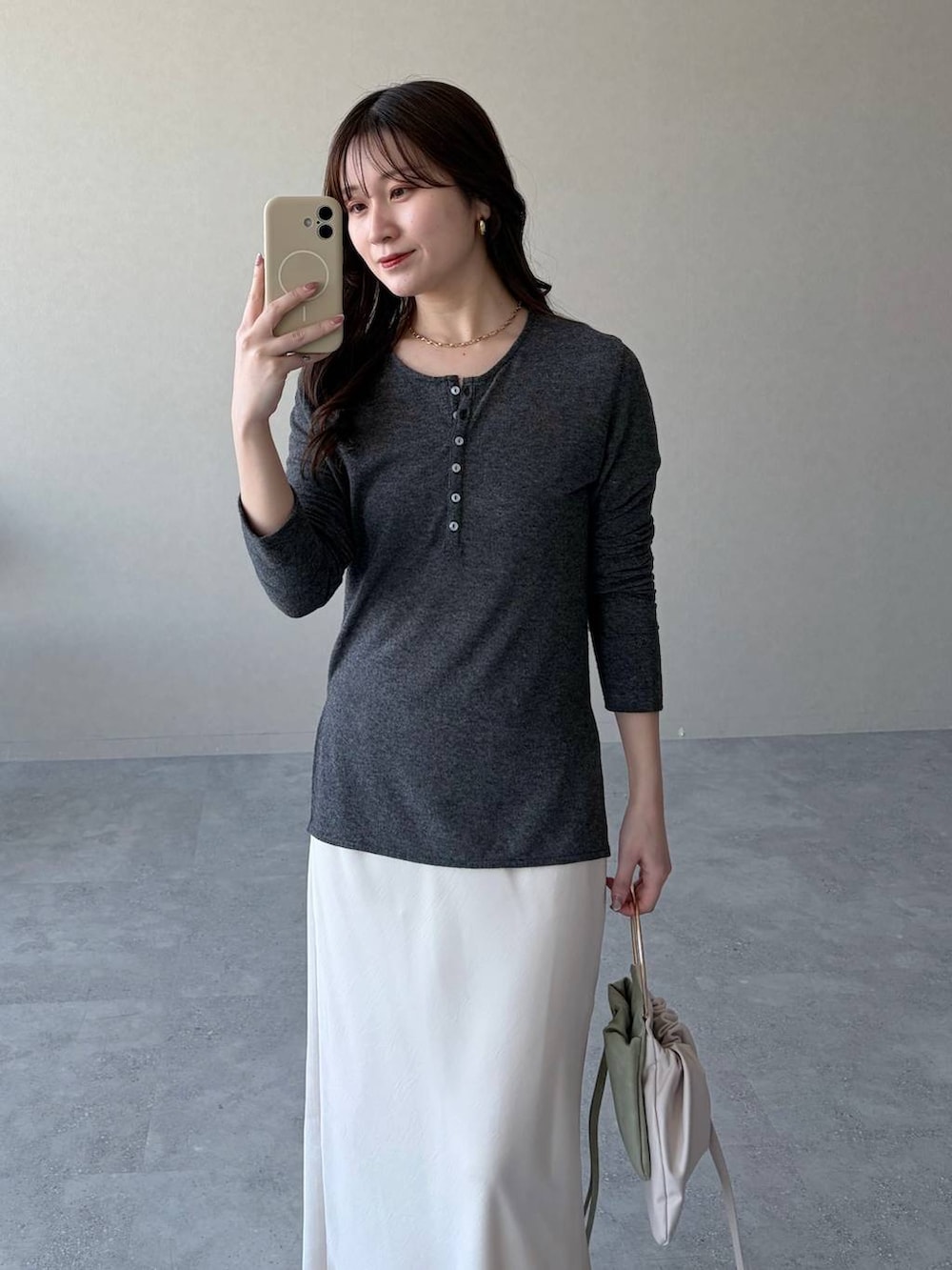 ブラウン系のサンダル、ホワイト系のスカート、グリーン系のハンドバッグを着用したレディースの春コーディネートの3枚目の写真