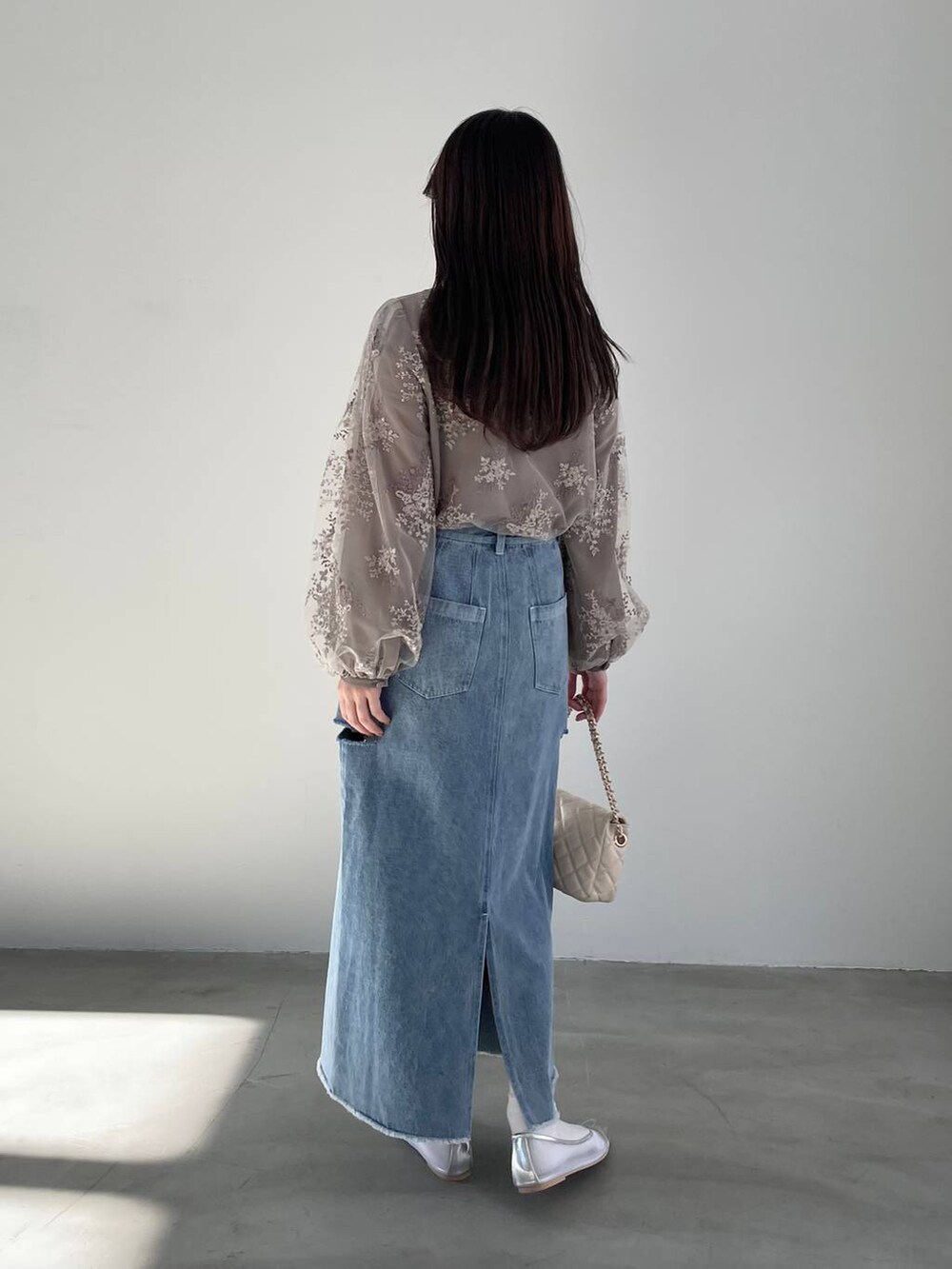 シルバー系のバレエシューズ、ブラウン系のシャツ/ブラウス、ホワイト系のショルダーバッグを着用したレディースの冬コーディネートの2枚目の写真