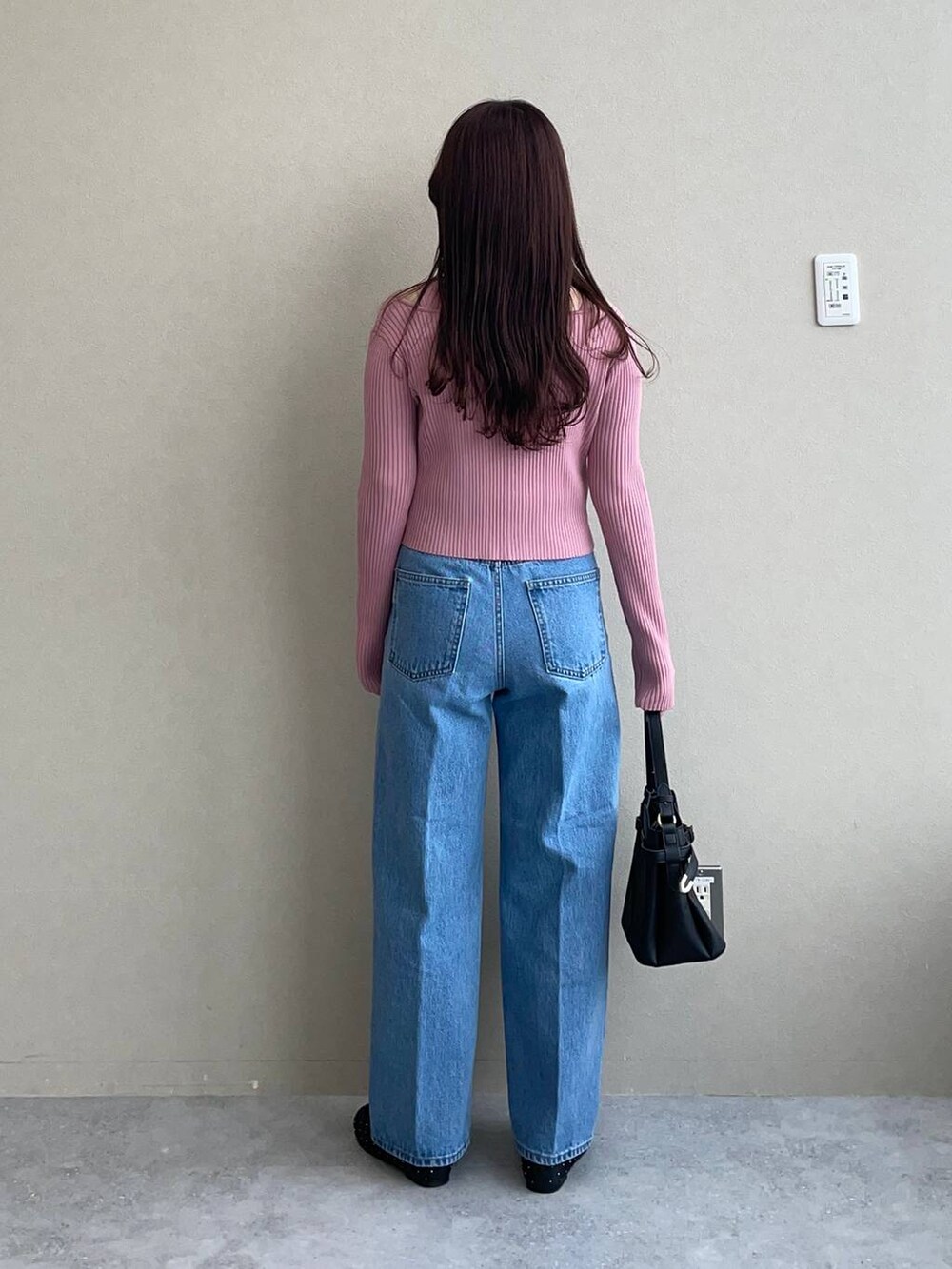 ブラック系のショルダーバッグ、ブルー系のデニムパンツ、ブラック系のバレエシューズを着用したレディースの冬コーディネートの2枚目の写真