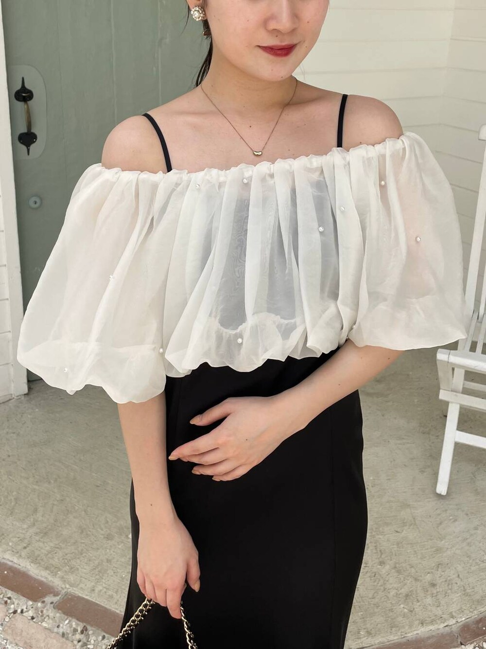 ブラック系のパンプス、ブラック系のショルダーバッグ、ブラック系のドレスを着用したレディースの夏コーディネートの3枚目の写真