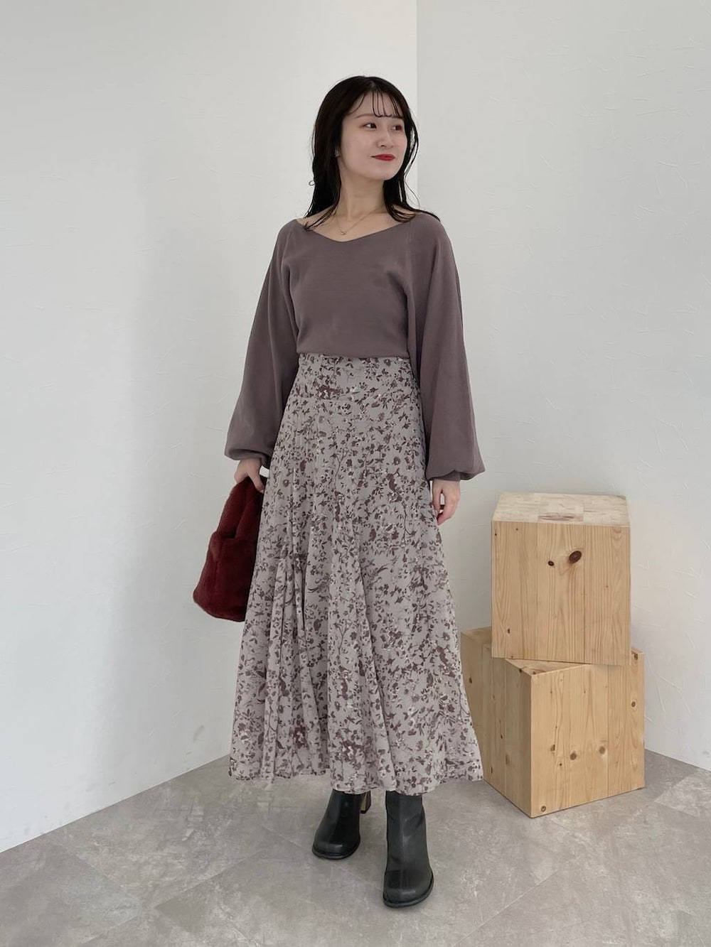 ブラック系のチェスターコート、グレー系のブーツ、ピンク系のハンドバッグを着用したレディースの秋コーディネートの4枚目の写真