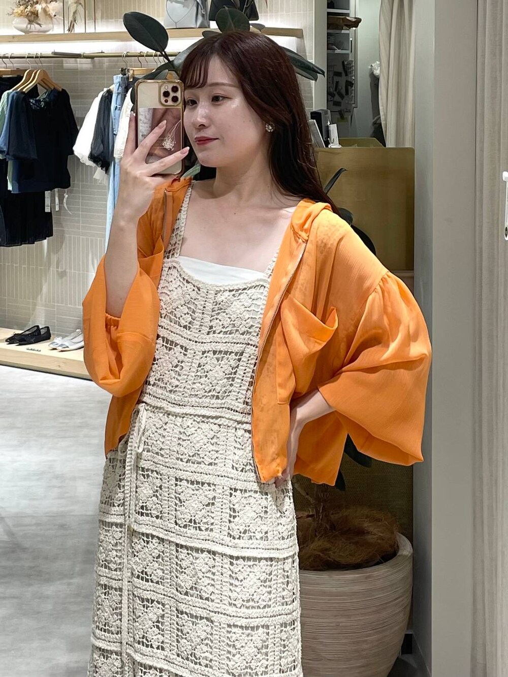 ホワイト系のワンピース、オレンジ系のパーカー、ホワイト系のサンダルを着用したレディースの夏コーディネートの5枚目の写真