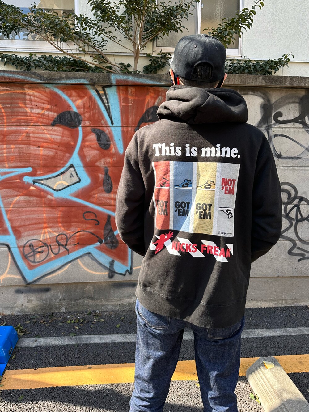ブルー系のスニーカー、ブルー系のデニムパンツ、ブラック系のパーカーを着用したメンズの春コーディネートの2枚目の写真