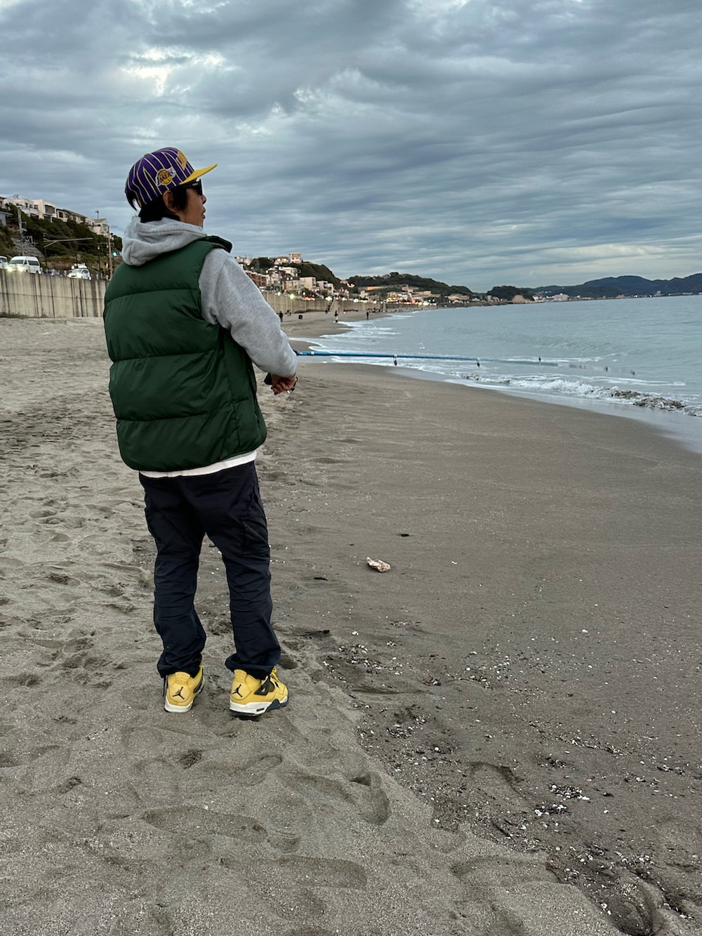 イエロー系のスニーカー、ブルー系のカーゴパンツ、グレー系のパーカーを着用したメンズの秋コーディネートの4枚目の写真