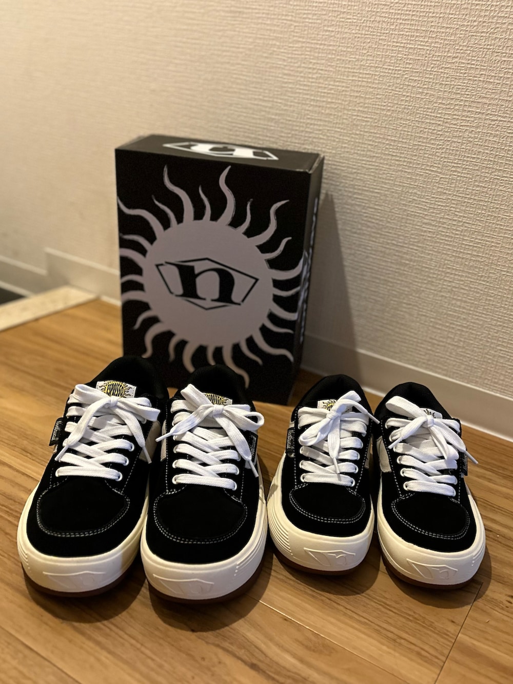 ブラック系のスニーカー、ブルー系のチノパンツ、グリーン系のダウンベストを着用したメンズの冬コーディネートの5枚目の写真