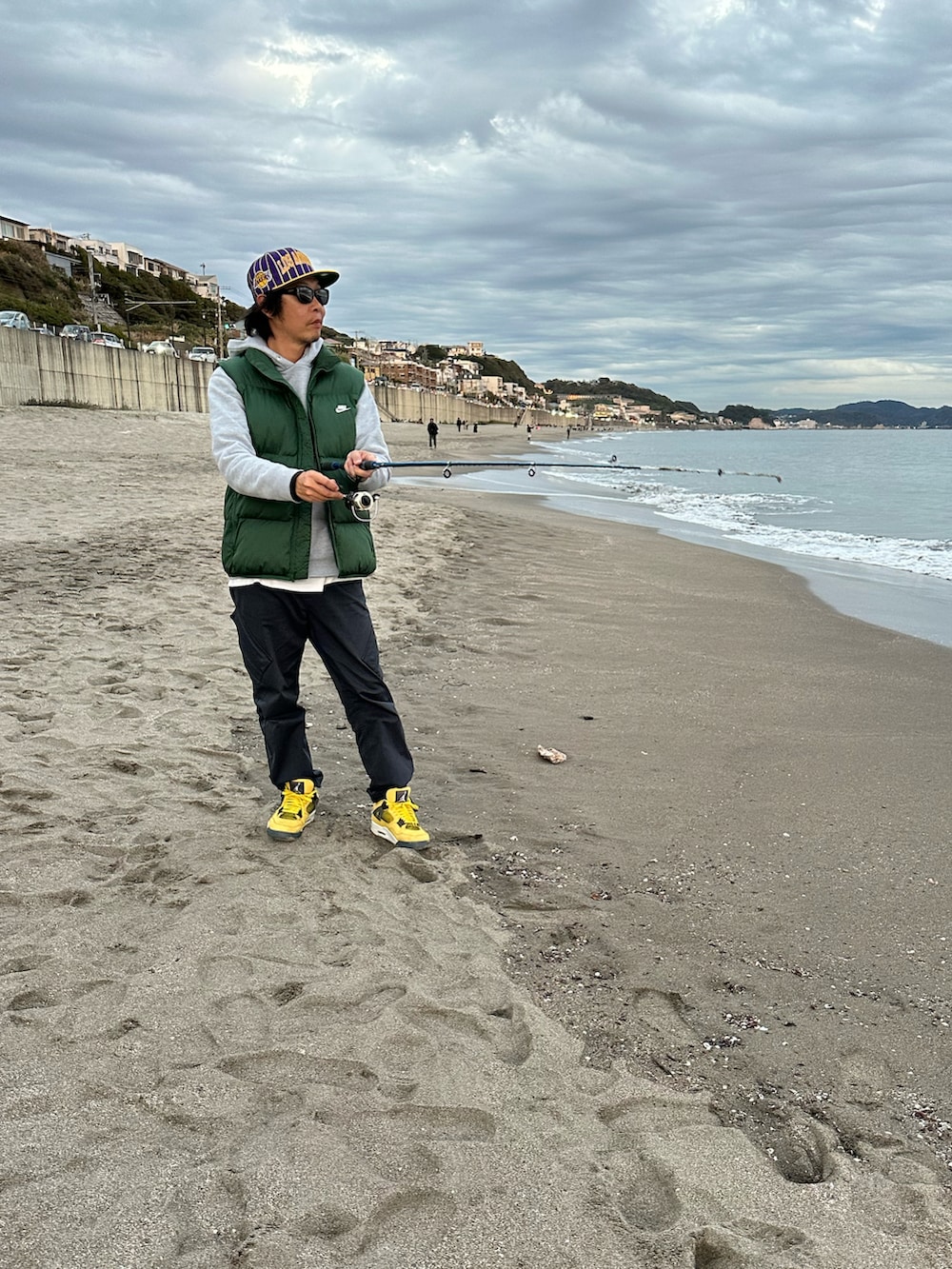 イエロー系のスニーカー、ブルー系のカーゴパンツ、グレー系のパーカーを着用したメンズの秋コーディネートの3枚目の写真