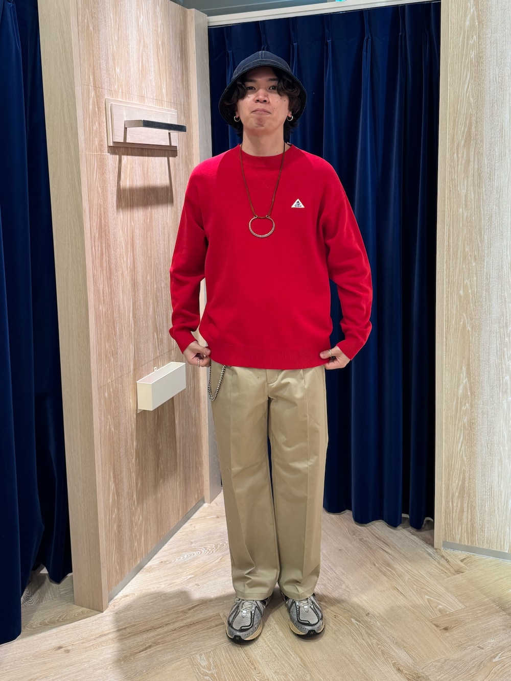 ブルー系のカバーオール、レッド系のスウェット、ベージュ系のチノパンツを着用したメンズの春コーディネートの5枚目の写真