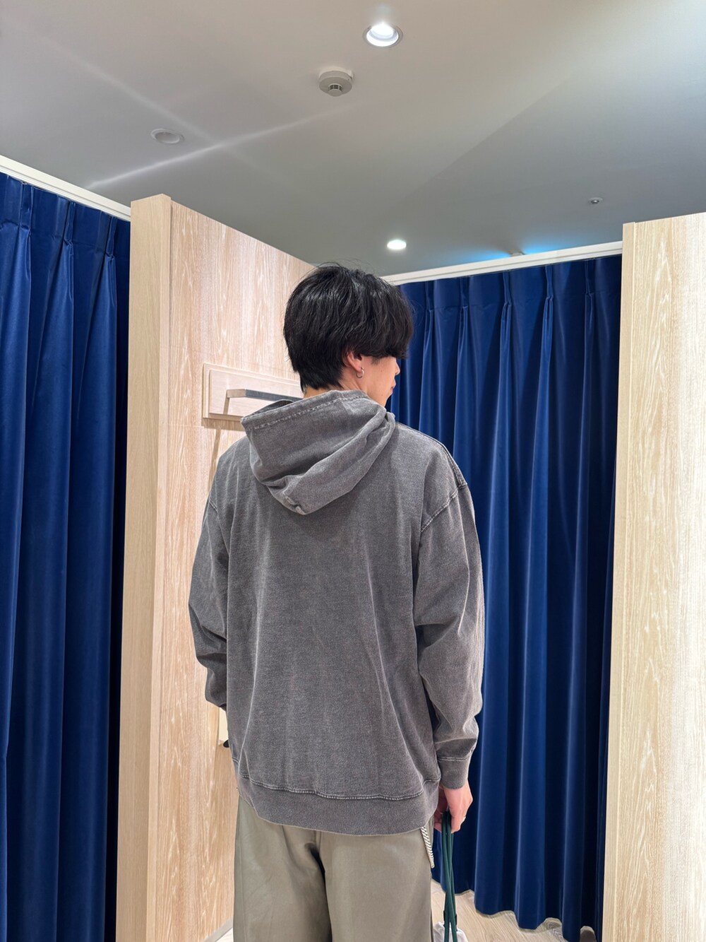ブラック系のパーカー、ホワイト系のショルダーバッグを着用したメンズの秋コーディネートの4枚目の写真