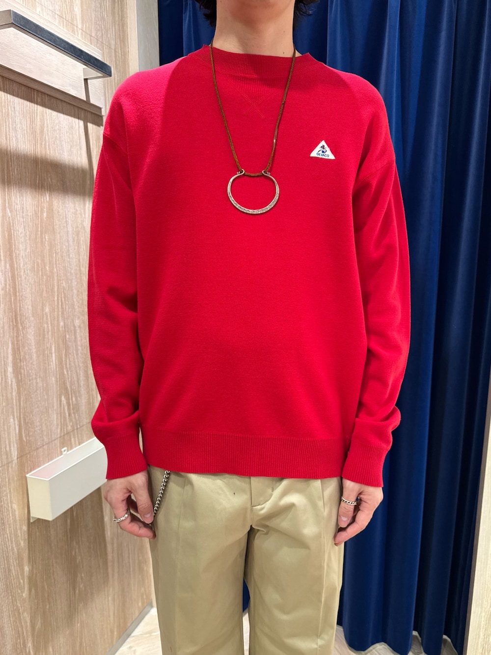 ブルー系のカバーオール、レッド系のスウェット、ベージュ系のチノパンツを着用したメンズの春コーディネートの6枚目の写真