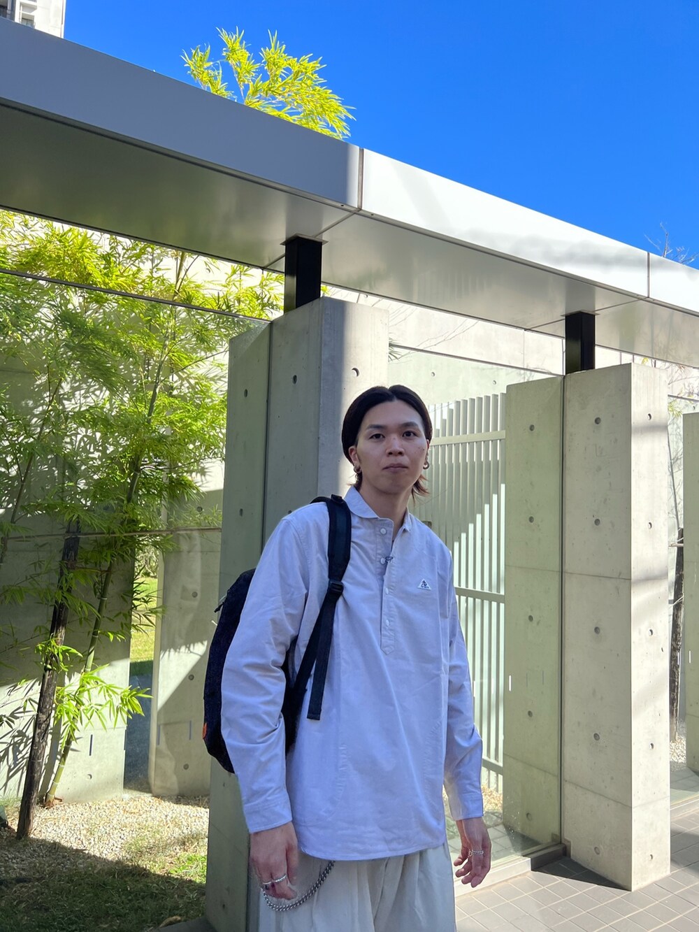 ベージュ系のシャツ/ブラウス、ホワイト系のその他パンツ、ブラック系のバックパック/リュックを着用したメンズの秋コーディネートの4枚目の写真