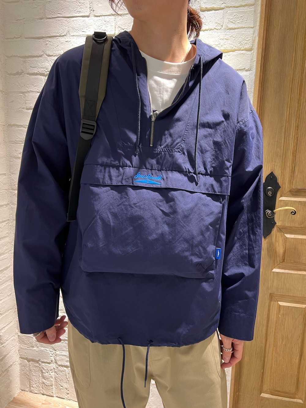 ブルー系のナイロンジャケット、ホワイト系のTシャツ/カットソー、ベージュ系のその他パンツを着用したメンズの春コーディネートの2枚目の写真