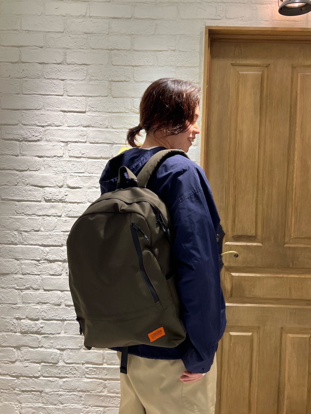 ブルー系のナイロンジャケット、ホワイト系のTシャツ/カットソー、ベージュ系のその他パンツを着用したメンズの春コーディネートの4枚目の写真