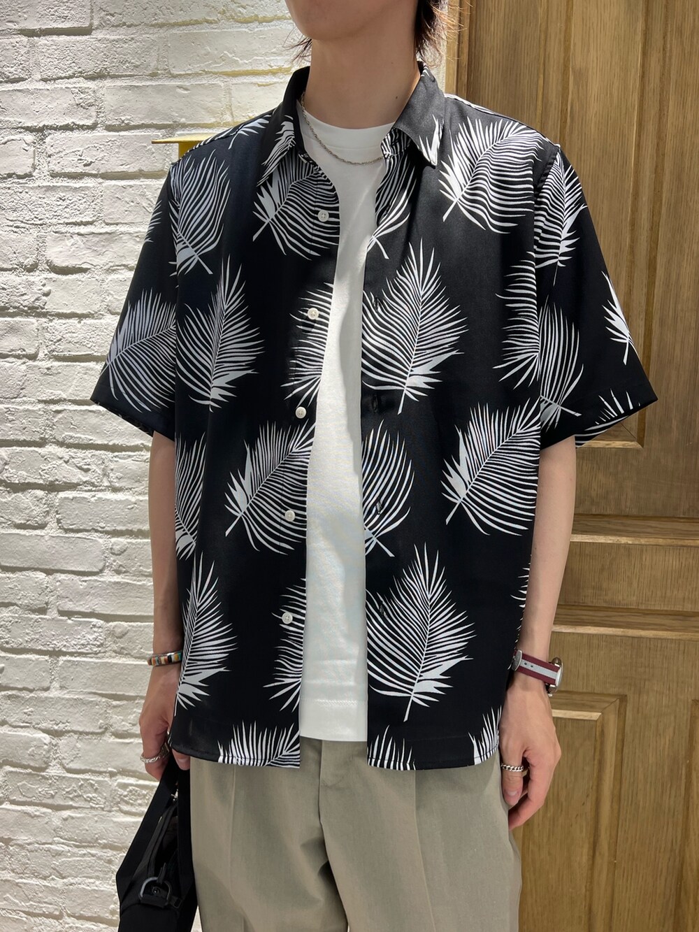 「FREDY&GLOSTER、universaloverall、oofos、GEVACO、柄シャツ、リゾートスタイル、スラックス、サンダル、ショルダーバッグ、トートバッグ、シャツスタイル、シャツコーデ、天王寺」｜「GLOSTERの【GLOSTER/グロスター】レギュラーカラー リーフ柄シャツ アロハ ボタニカル ビッグシルエット（シャツ/ブラウス、ブラック系）」を使った、ふなさん（メンズ・178cm）の夏コーディネートの2枚目の写真