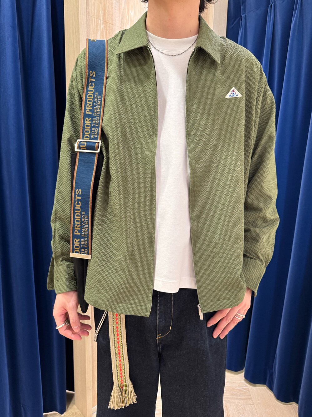 グリーン系のブルゾン、ブラック系のショルダーバッグを着用したメンズの冬コーディネートの2枚目の写真