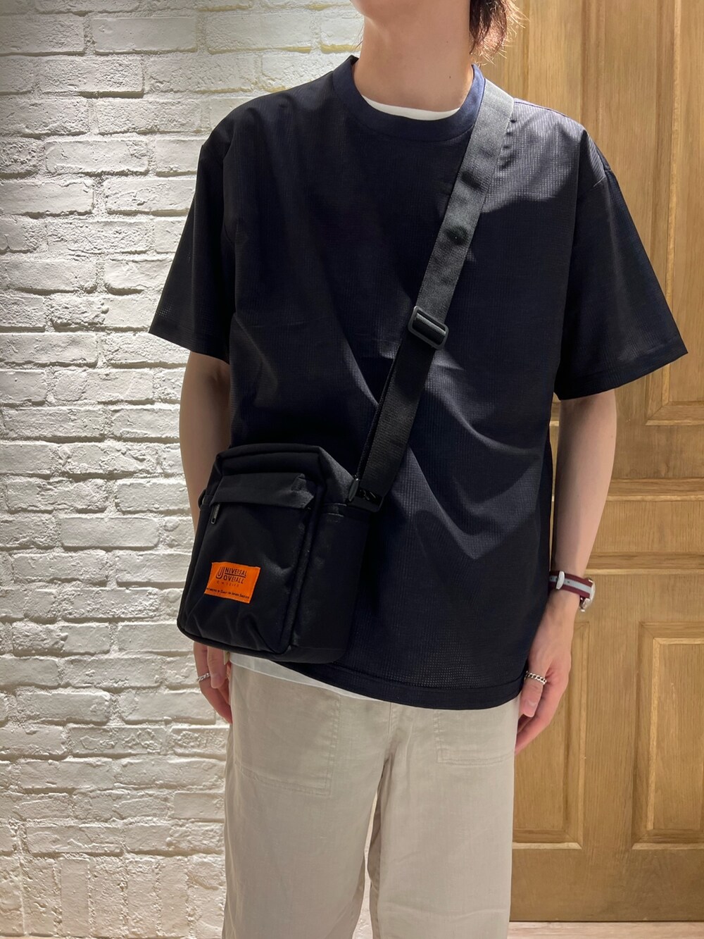 ブルー系のTシャツ/カットソー、ブラック系のショルダーバッグ、ホワイト系のその他パンツを着用したメンズの夏コーディネートの2枚目の写真