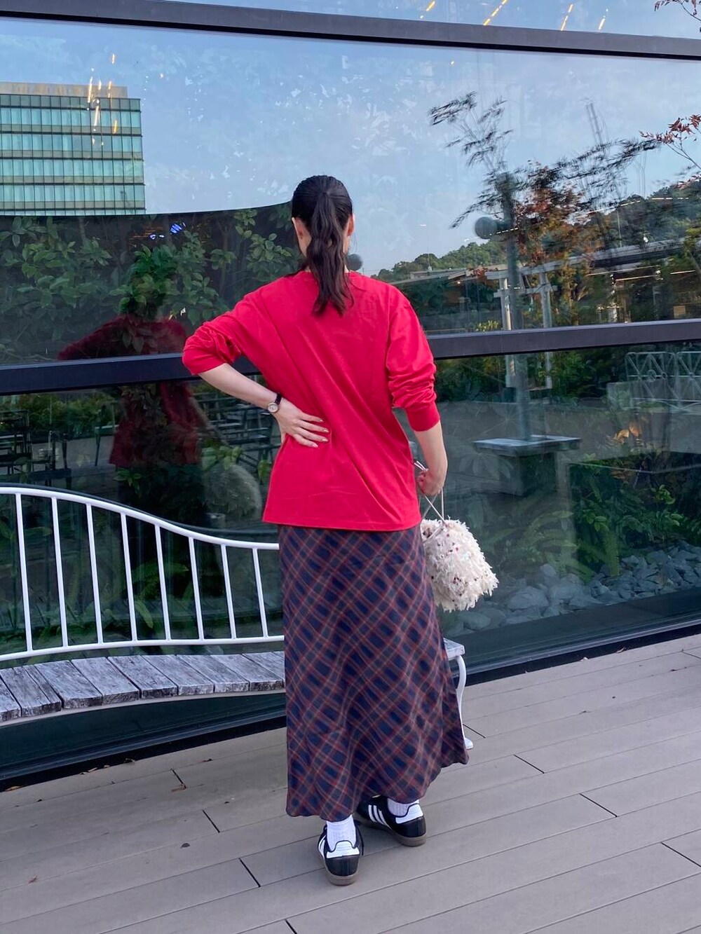 ブラック系のスニーカー、ホワイト系のハンドバッグ、その他のTシャツ/カットソーを着用したレディースの秋コーディネートの3枚目の写真