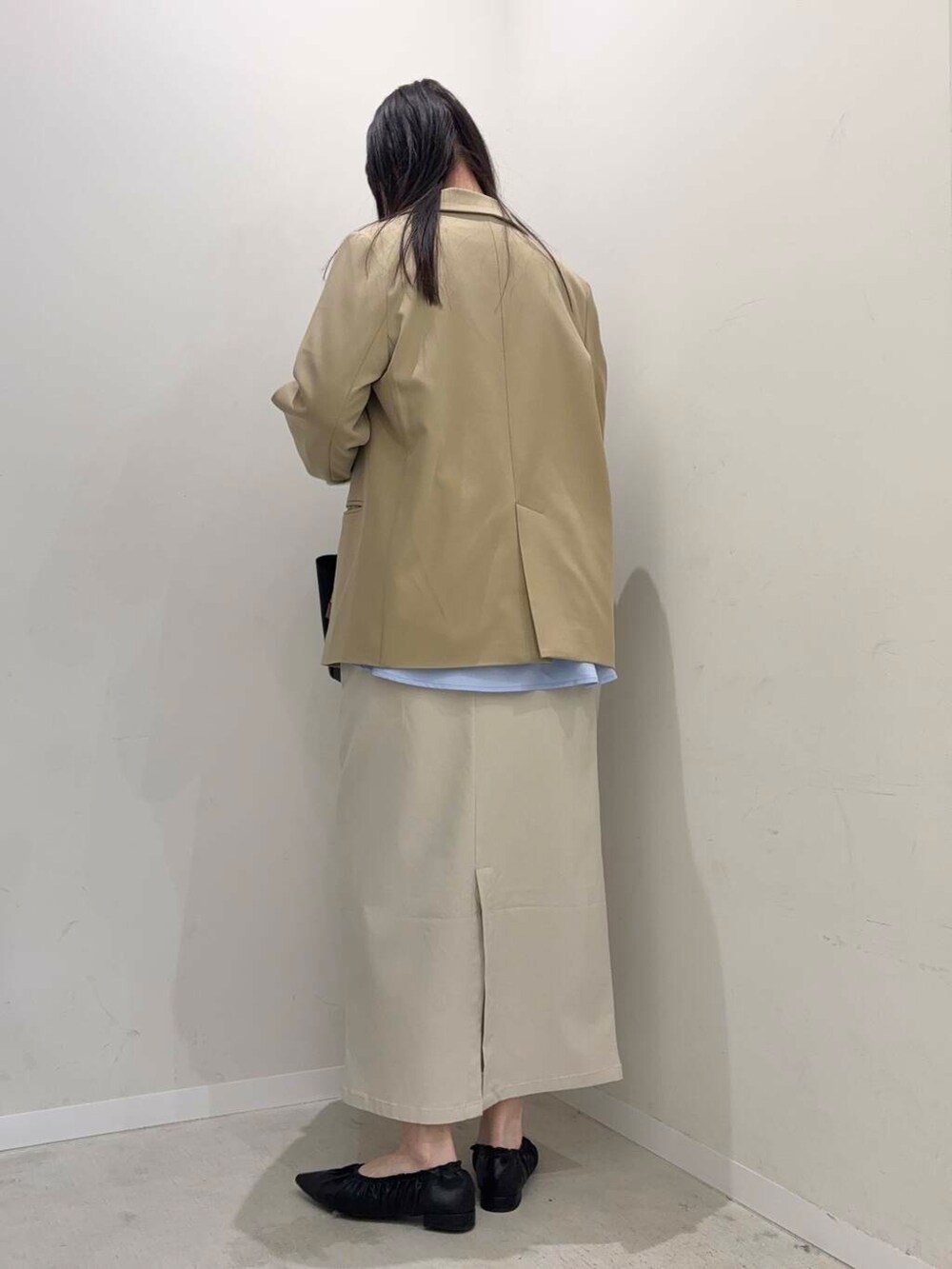 ブラウン系のトートバッグ、ベージュ系のスカート、ベージュ系のテーラードジャケットを着用したレディースの春コーディネートの2枚目の写真