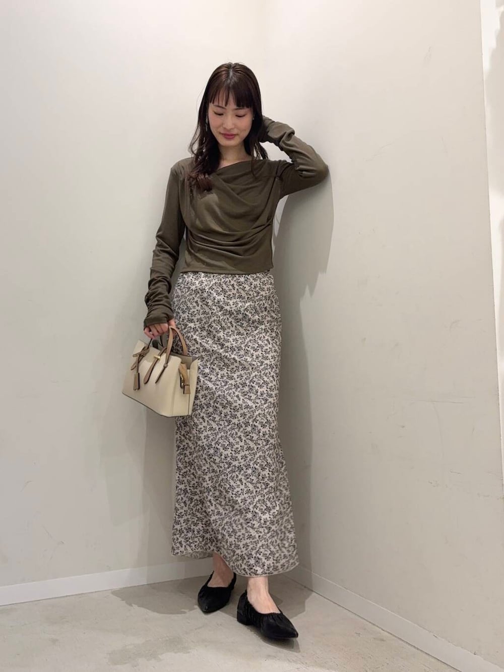 ホワイト系のハンドバッグ、ブラック系のバレエシューズ、グリーン系のTシャツ/カットソーを着用したレディースの春コーディネートの3枚目の写真