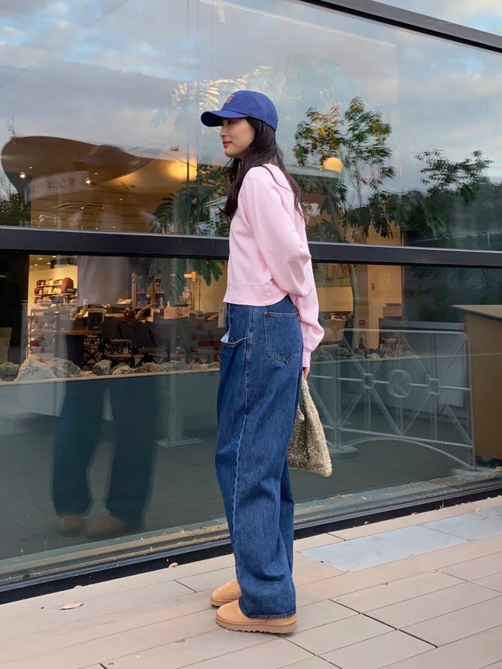 ブルー系のデニムパンツ、ゴールド系のトートバッグ、ブラウン系のブーツを着用したレディースの冬コーディネートの4枚目の写真