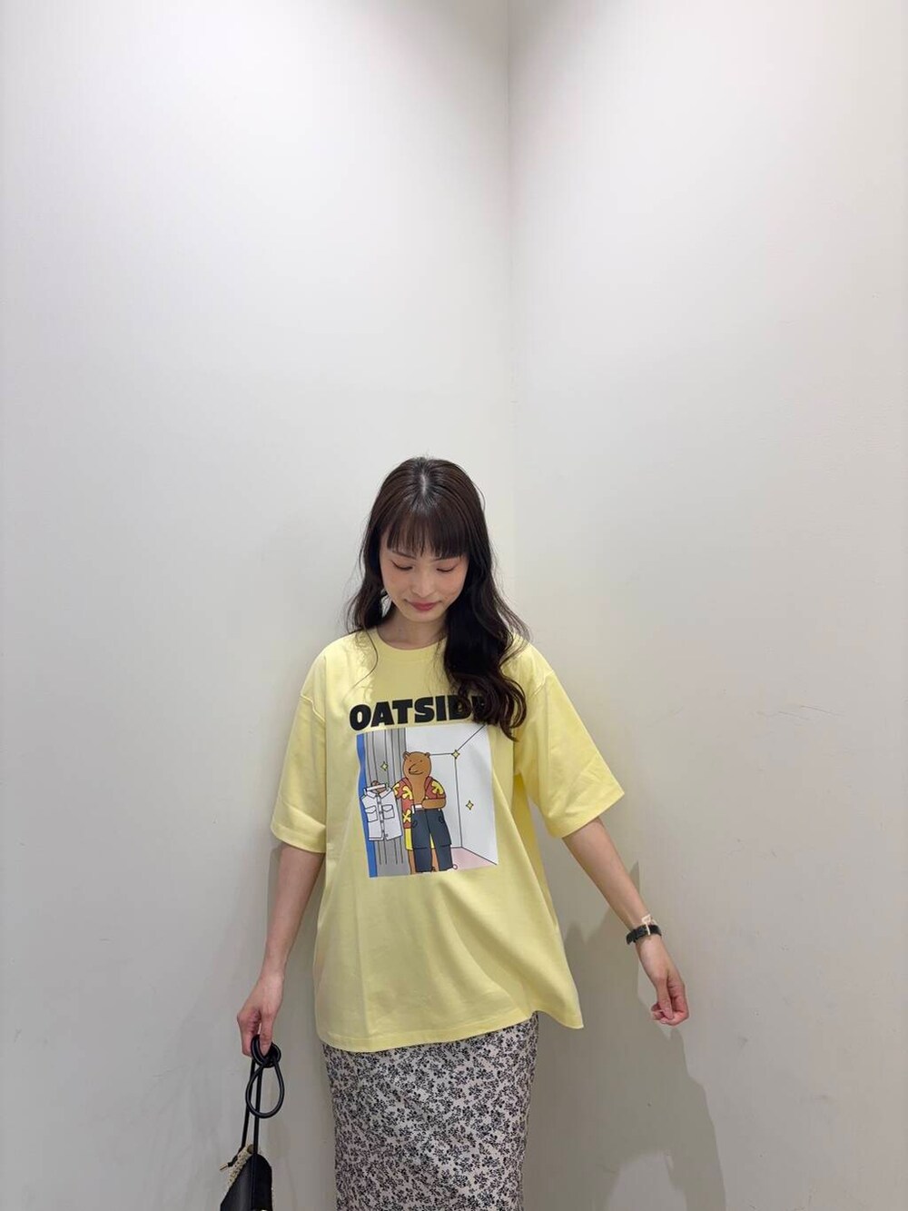 ベージュ系のショルダーバッグ、ホワイト系のスカート、ブラック系のサンダルを着用したレディースの春コーディネートの2枚目の写真