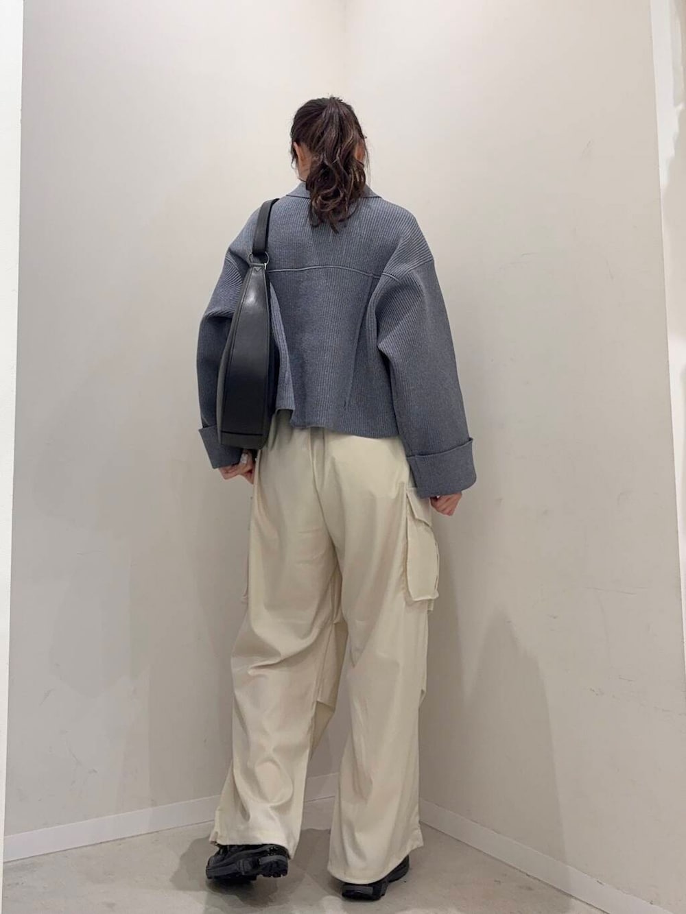 ブラック系のショルダーバッグ、ブルー系のその他アウター、ブラック系のスニーカーを着用したレディースの春コーディネートの2枚目の写真