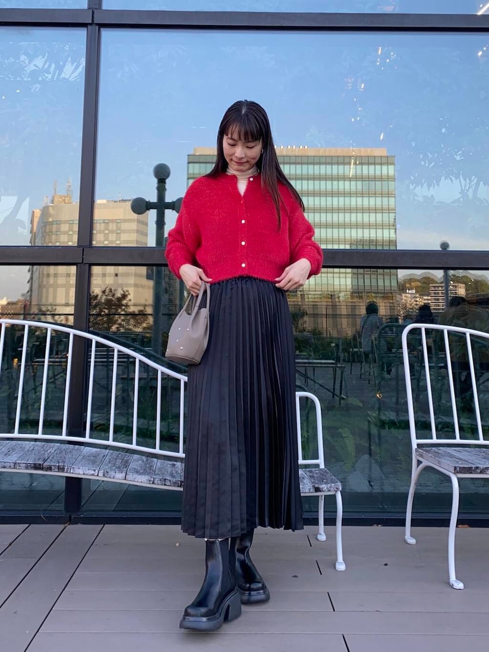 ブラック系のブーツ、ホワイト系のTシャツ/カットソー、グレー系のショルダーバッグを着用したレディースの冬コーディネートの2枚目の写真