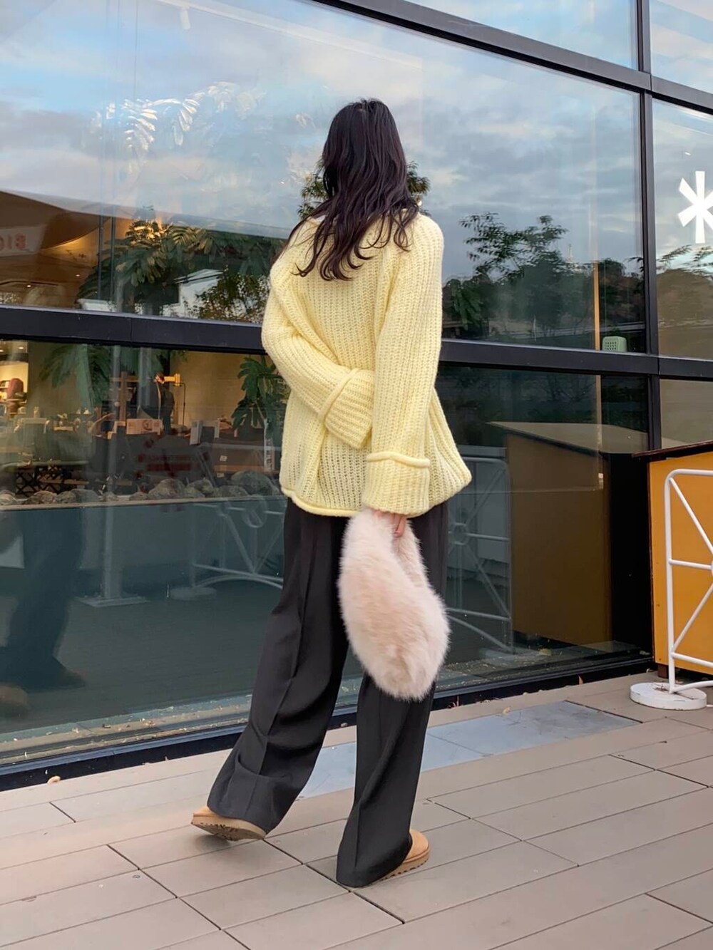 ベージュ系のハンドバッグ、ブラウン系のブーツ、グレー系のその他パンツを着用したレディースの冬コーディネートの2枚目の写真