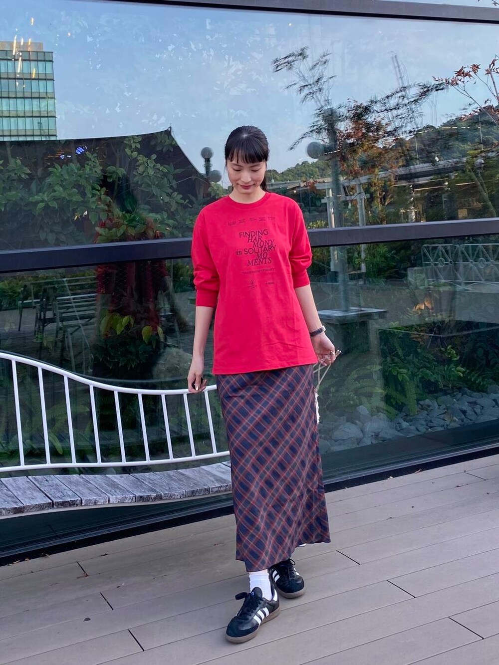 ブラック系のスニーカー、ホワイト系のハンドバッグ、その他のTシャツ/カットソーを着用したレディースの秋コーディネートの2枚目の写真