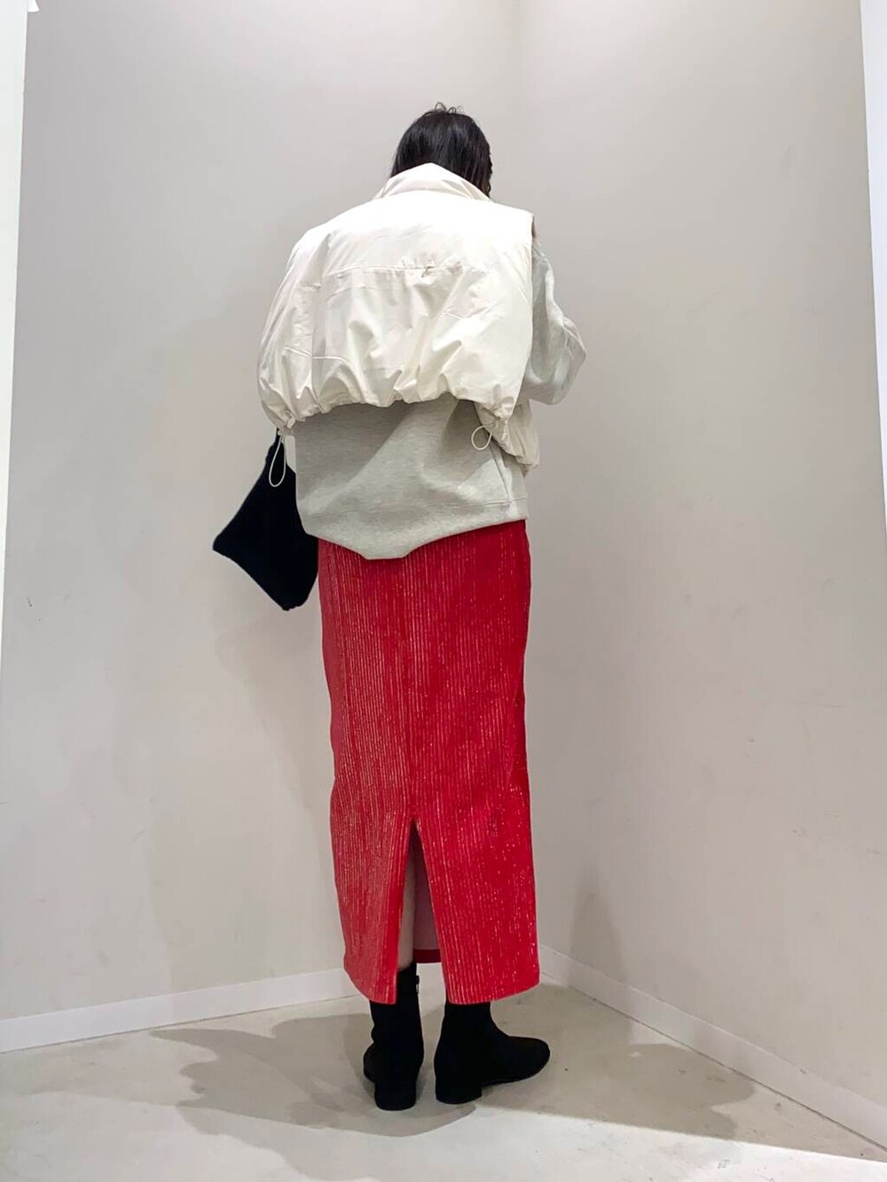 ブラック系のブーツ、ホワイト系のダウンベスト、その他のスウェットを着用したレディースの秋コーディネートの2枚目の写真