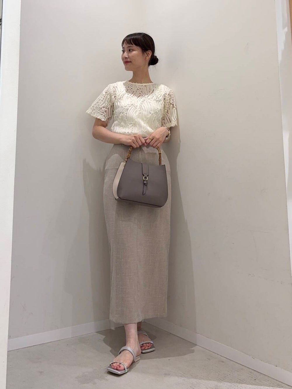 シルバー系のサンダル、ホワイト系のシャツ/ブラウス、ベージュ系のスカートを着用したレディースの夏コーディネートの3枚目の写真