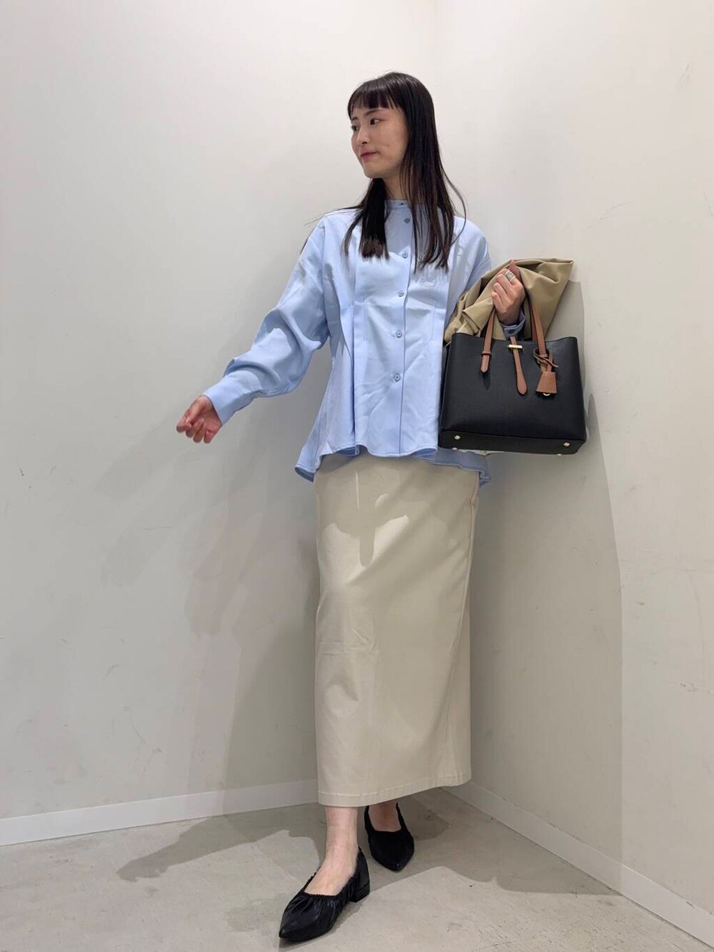 ブラウン系のトートバッグ、ベージュ系のスカート、ベージュ系のテーラードジャケットを着用したレディースの春コーディネートの3枚目の写真